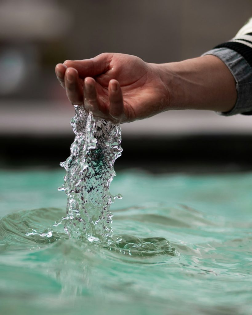 a-hand-plays-with-flowing-water-fihhzbesex0